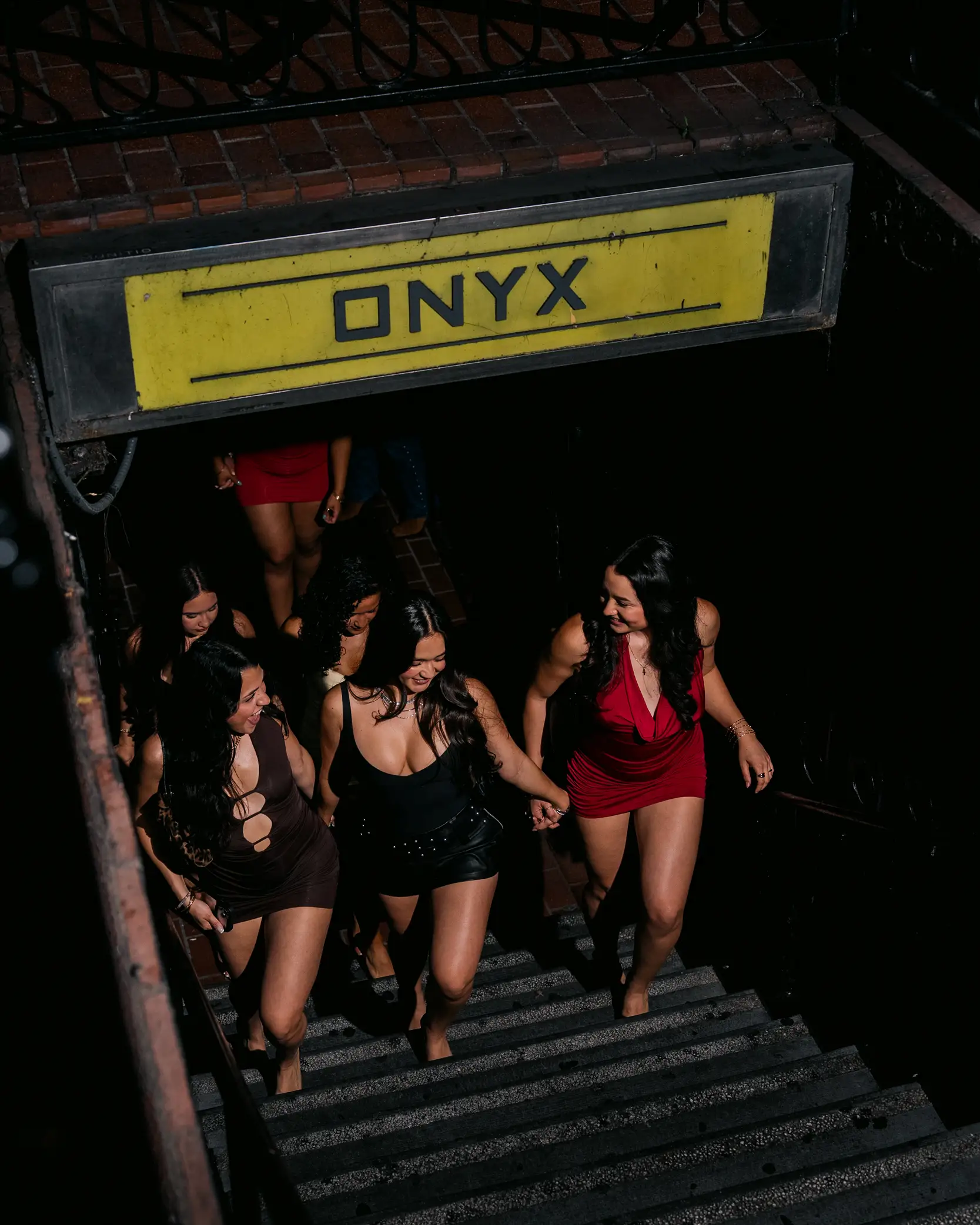 Guests walking up the stairs beneath the ONYX sign at Onyx Nightclub entrance